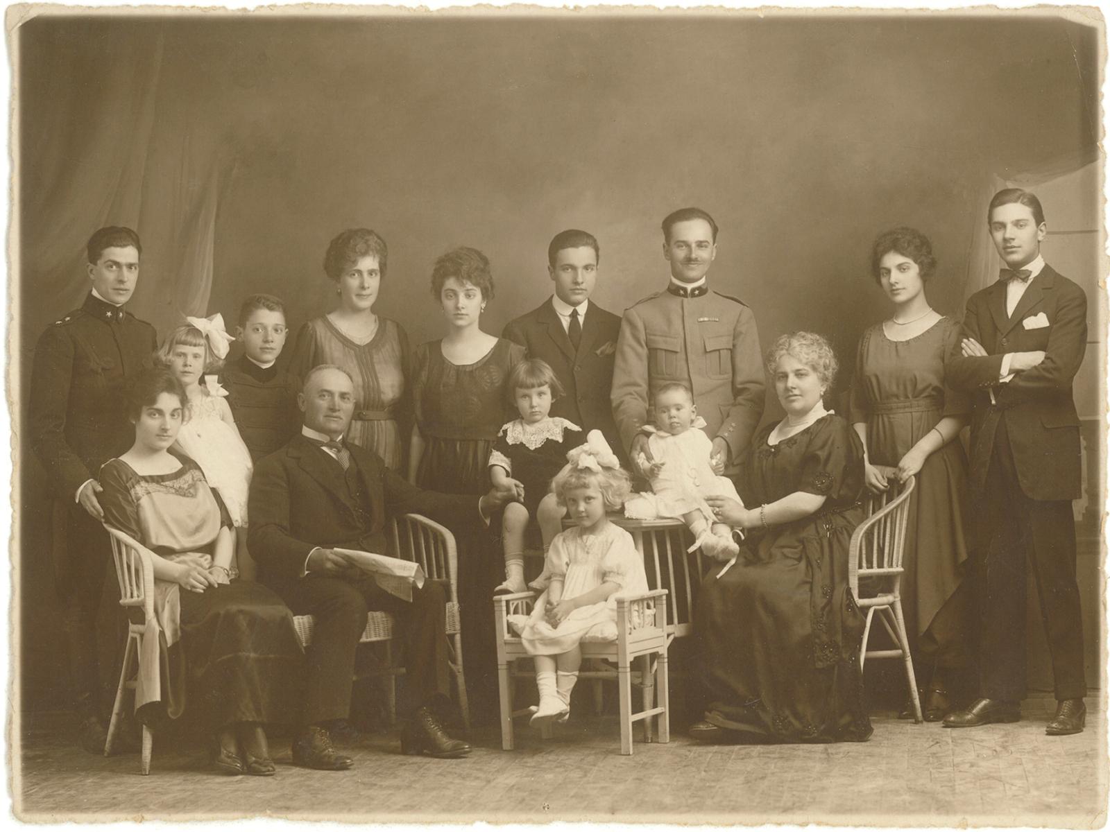 Foto d'epoca di famiglia numerosa, atmosfera solenne e affettuosa.